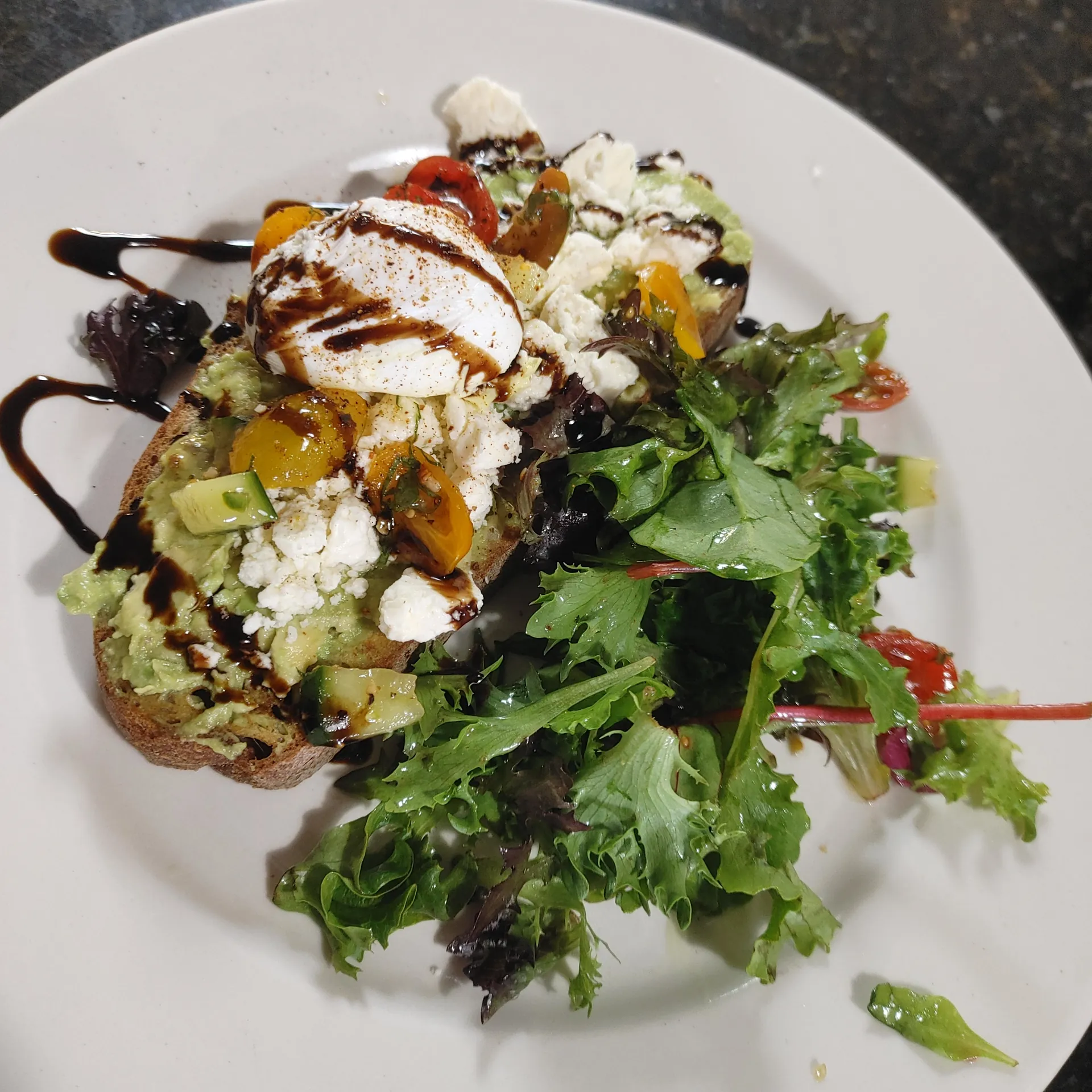 Balsamic avocado toast with poached egg and dressed greens