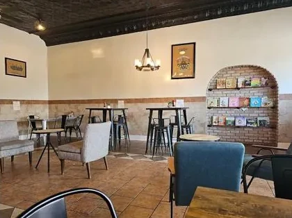 Inside Milo Coffee House — café tables, a warm brick book nook, and downtown light